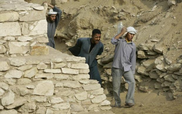 Des travailleurs transportant des pierres