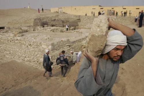 Travailleur transportant un rocher